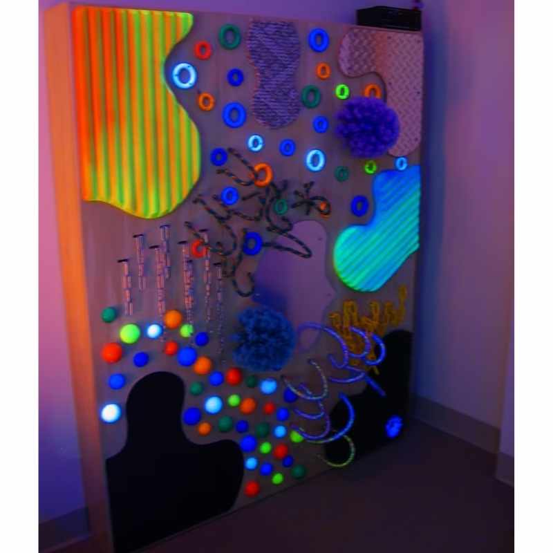 TFH UV Textured Wall glowing under blacklight, showing the full range of UV-reactive textures on this sensory wall panel