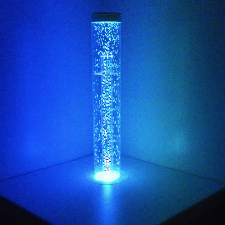 TFH Hurricane Tube, a waterless bubble tube glowing blue in a darkened sensory room corner
