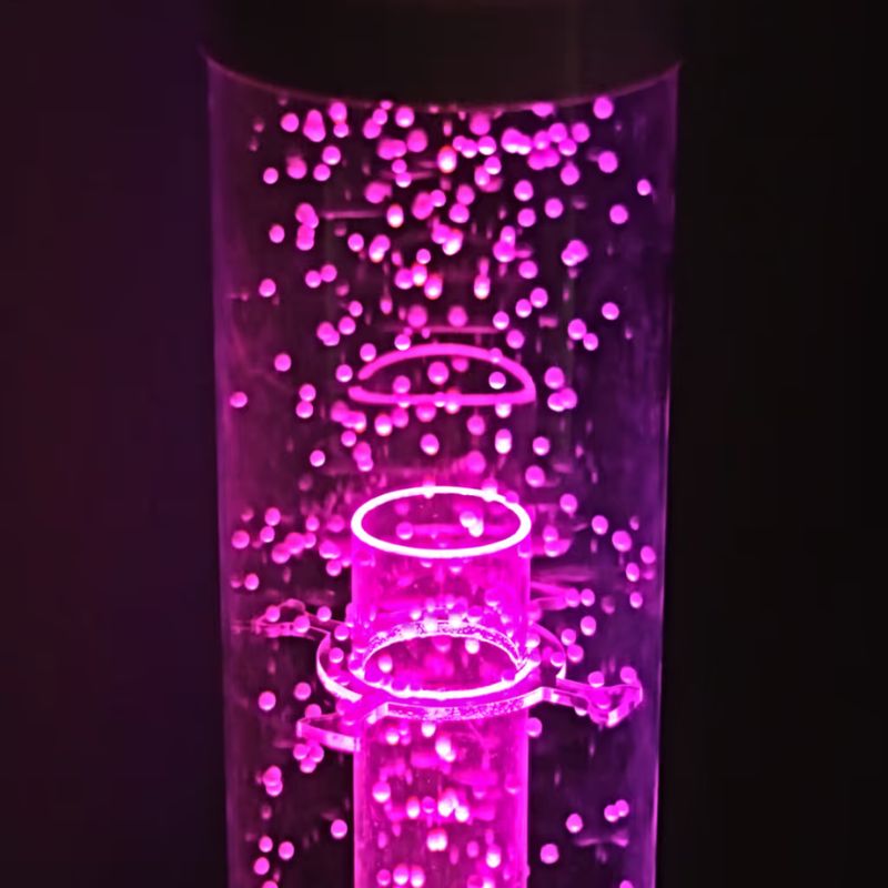 Close up of the TFH Hurricane Tube's waterless beads lit pink inside the sensory bubble tube column