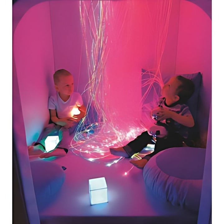 Child engaged in sensory play inside the Wesco Sensory Cabin with purple lighting, demonstrating this portable sensory room cabin as a calm corner in a therapy or school setting