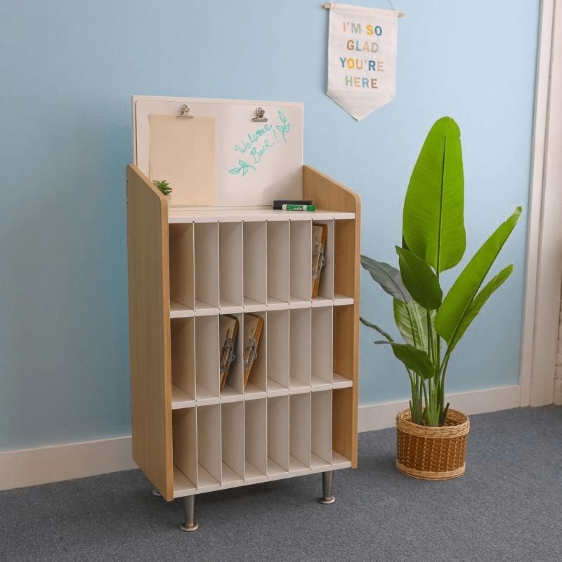 Full indoor view of the Whitney Brothers elevatED Mail and Message Center in a classroom environment, showing the 50" tall organiser with 24 removable-divider slots and classroom communication display board
