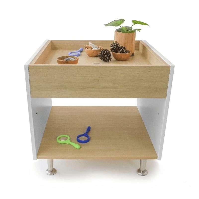 Whitney Brothers elevatED Toddler Discovery Table with toys on the surface, showing the raised perimeter lip that prevents objects falling off the edge of the toddler activity table