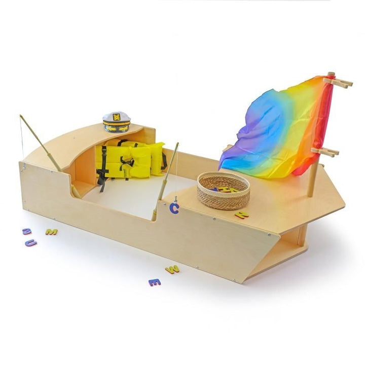 Full view of the Whitney Brothers Imagination Boat with sail flag and play props, showing the dramatic play boat in a classroom setting with the four-child open deck and bow crawl-through