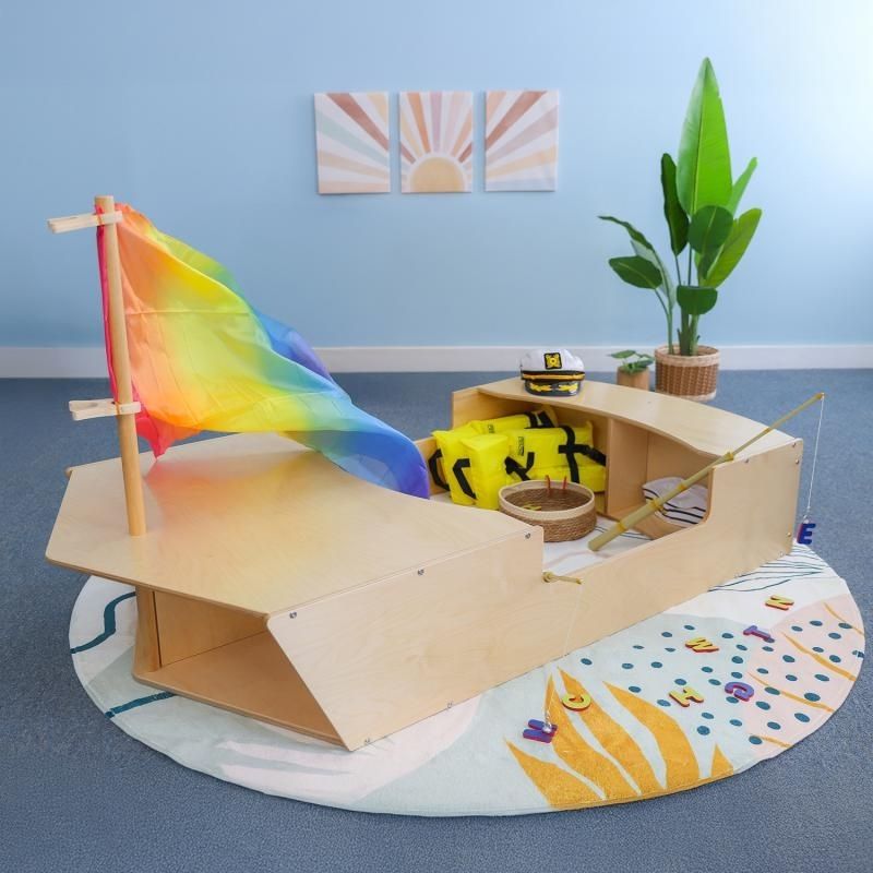 Whitney Brothers Imagination Boat WB1170 indoor product view showing the full 69.5"x36.5" birch plywood classroom dramatic play boat with crawl-through bow and under-seat cubby storage