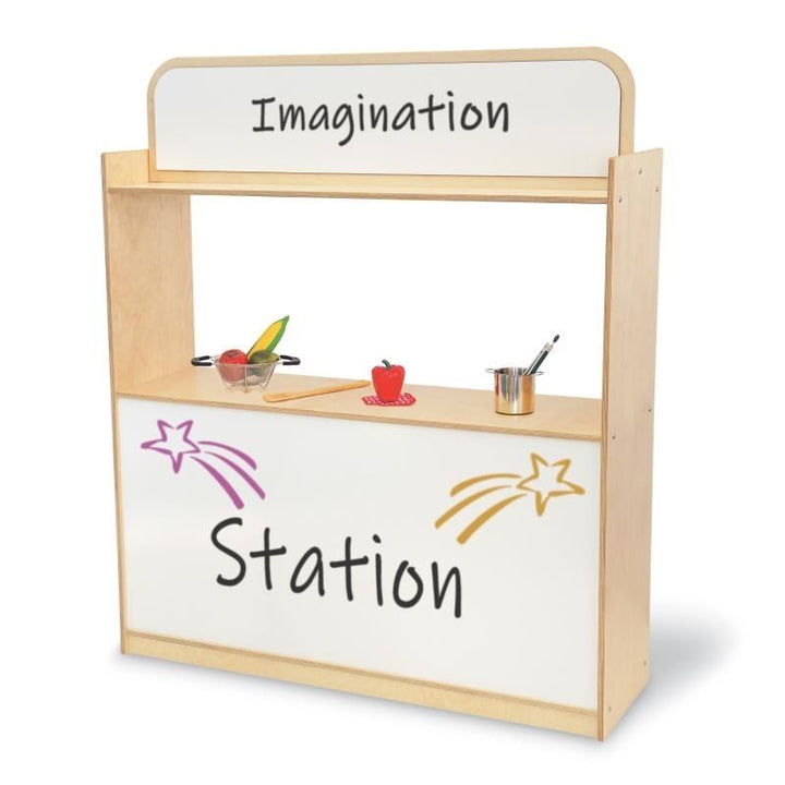 Front view of the Whitney Brothers Imagination Station with sample dry erase signage, showing the stage opening, upper and lower dry erase boards, and 48.75" wide dramatic play unit