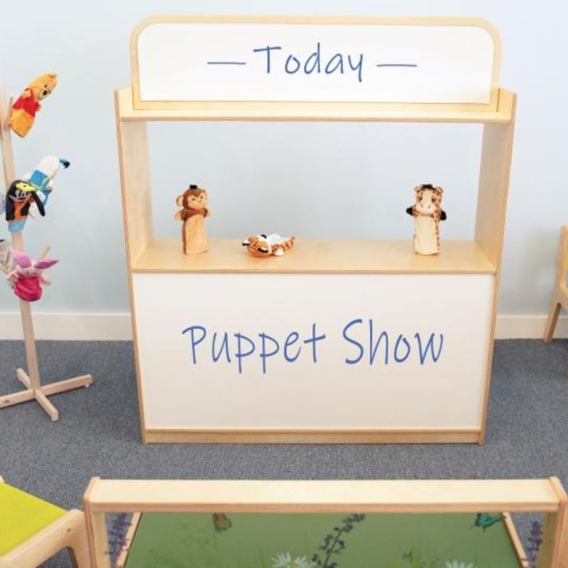 Child presenting a puppet show using the Whitney Brothers Imagination Station as a puppet theatre, showing the 24" centre stage opening and the dry erase board signage surface
