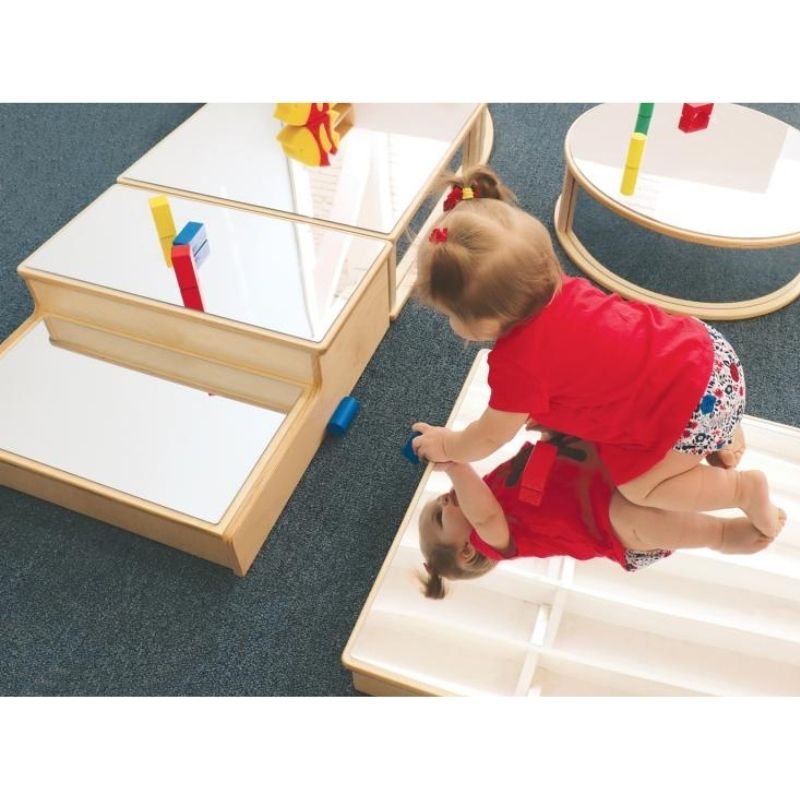 Crawling infant engaging with the Whitney Brothers Infant Floor Mirror Set, showing the floor-level mirror blocks supporting gross motor development and self-awareness play