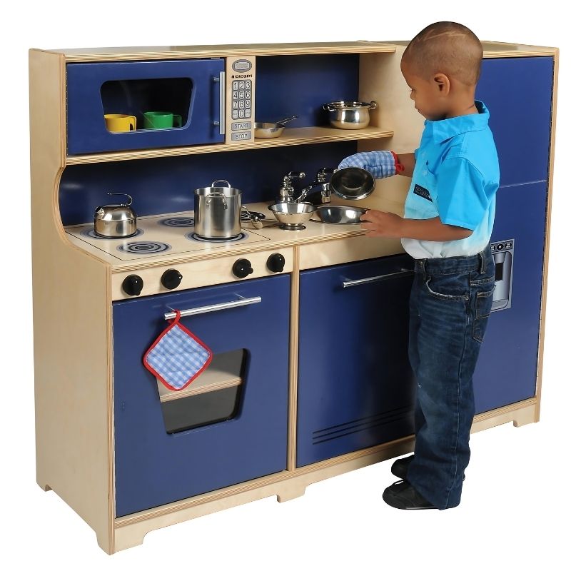Child engaged in pretend cooking at the Whitney Brothers Monaco Combo Kitchen, showing the realistic stove dials and integrated all-in-one birch plywood play kitchen design