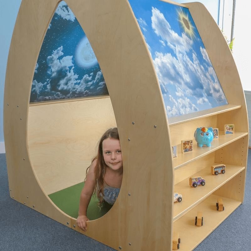 Child independently playing inside the Whitney Brothers Sky View Sanctuary, showing the comfortable interior with day sky acrylic panels visible above in the biophilic quiet space