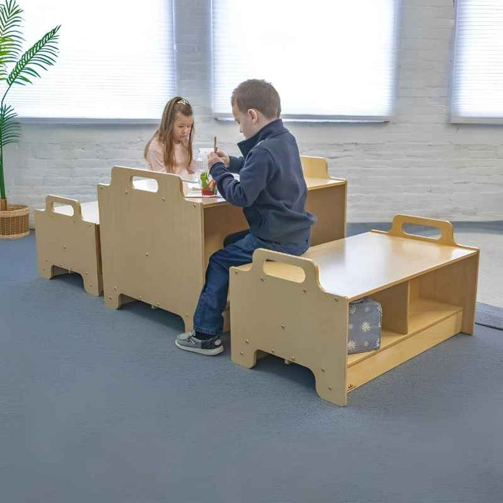 Two children using the Whitney Brothers Stack-Able Table and Stack-Able Bench together in an early learning classroom, demonstrating the full Stack-Able collection configured as a collaborative learning zone