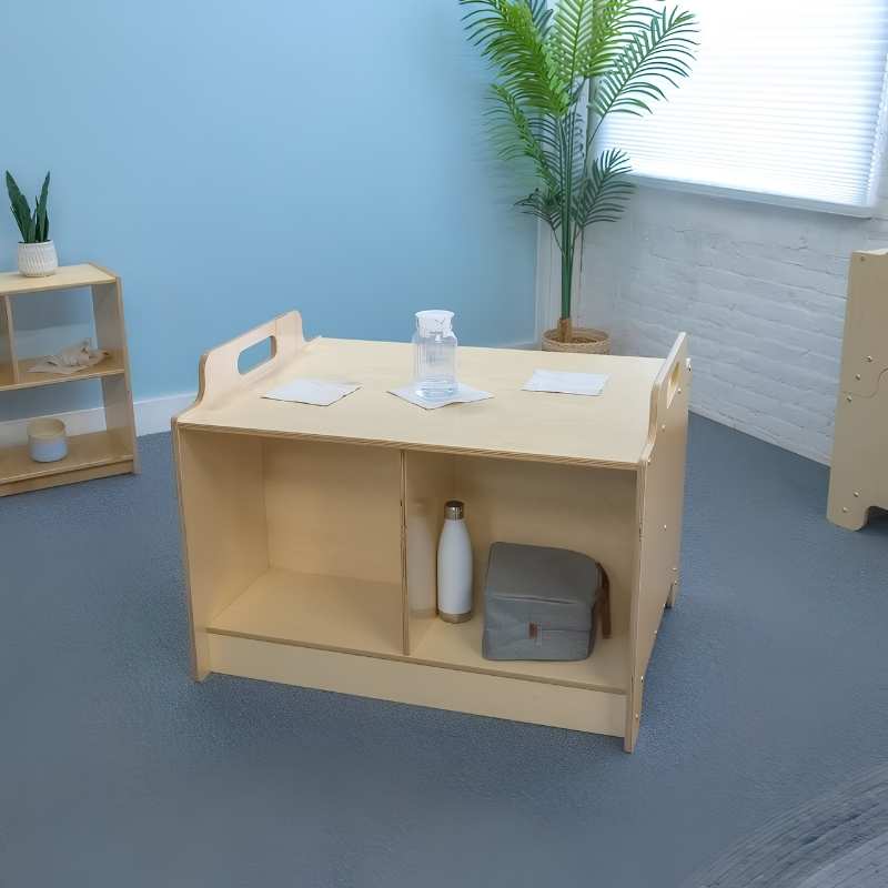 Whitney Brothers Stack-Able Table in a classroom lifestyle setting with natural light, showing below-surface storage in use and coordinating early learning furniture in the background