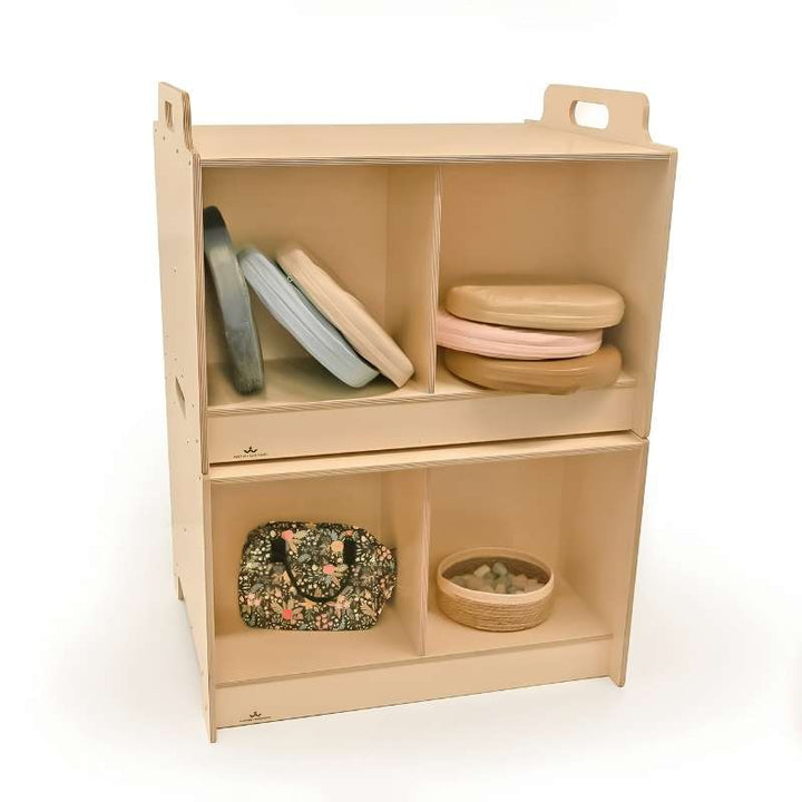 Whitney Brothers Stack-Able Tables stacked as a two-sided storage cabinet on white background, with compartments organised with cushion seats, balance discs, and classroom loose-parts materials