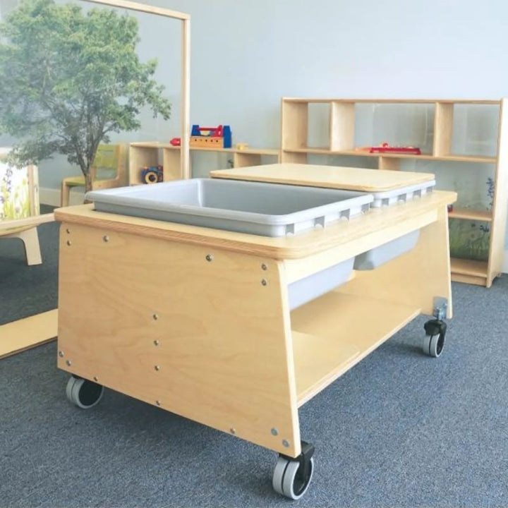 Side view of the Whitney Brothers Whitney Plus Two Tub Sand & Water Table with one tub open, showing the elevated tub design and HPL maple laminate surface