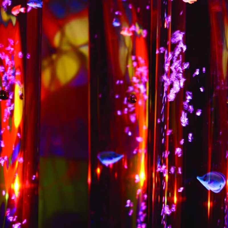 Close-up of a TFH Wireless Bubble Tube with coloured LED light and rising bubbles, a cordless sensory light for calming visual stimulation