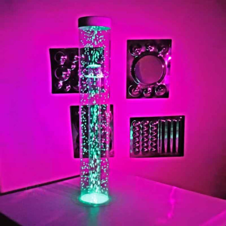 TFH Wireless Hurricane Tube set up in a sensory room alongside tactile wall panels, glowing green for a calming environment